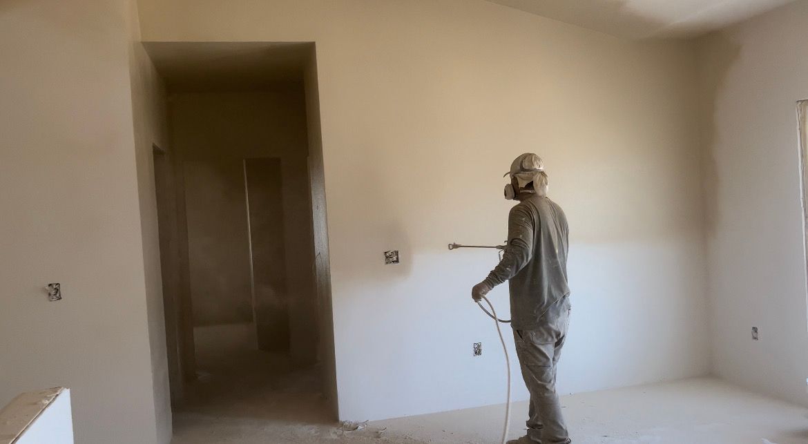 A man is painting a wall with a brush.