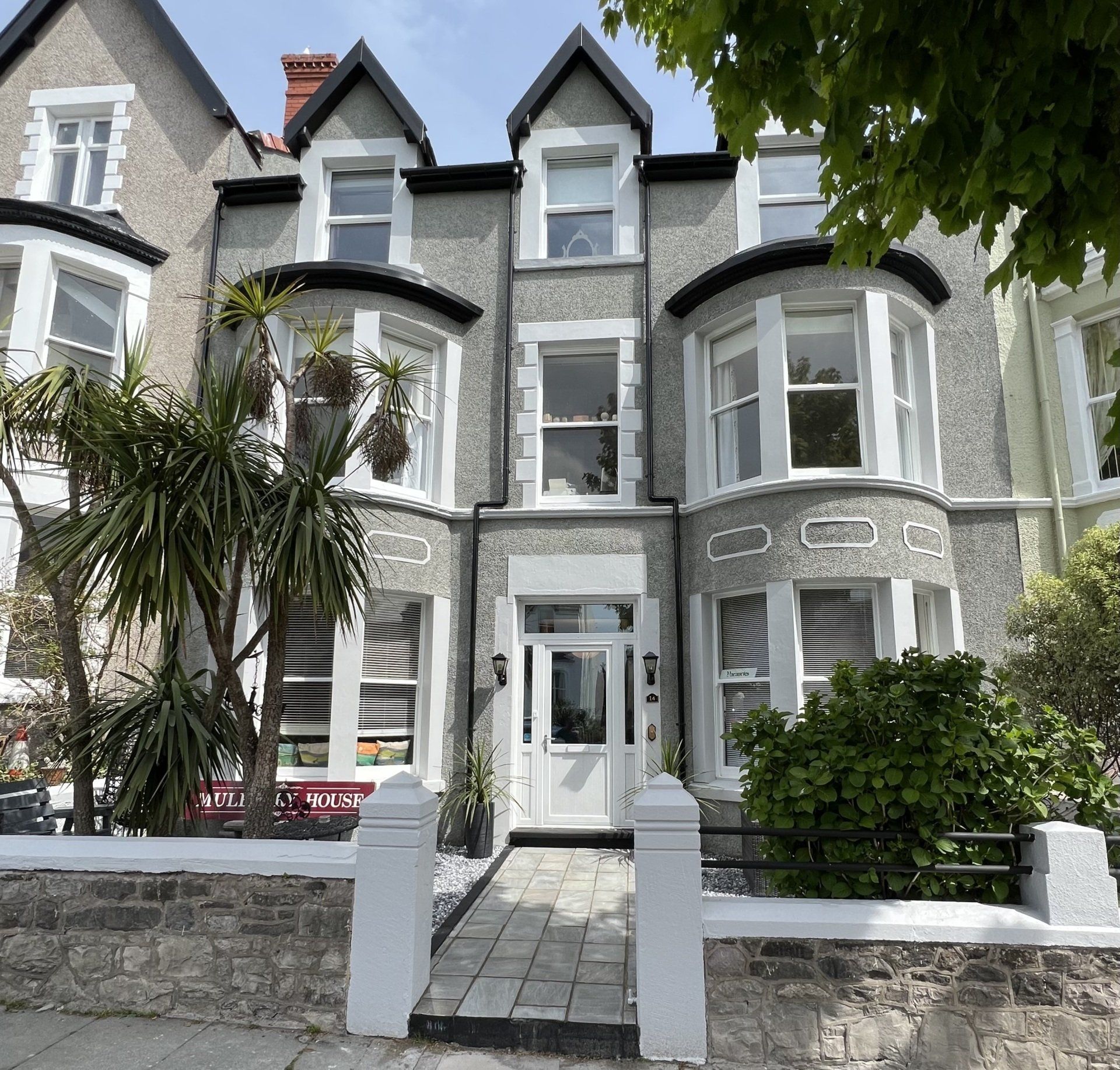 A large house with a sign that says ' for sale ' on it