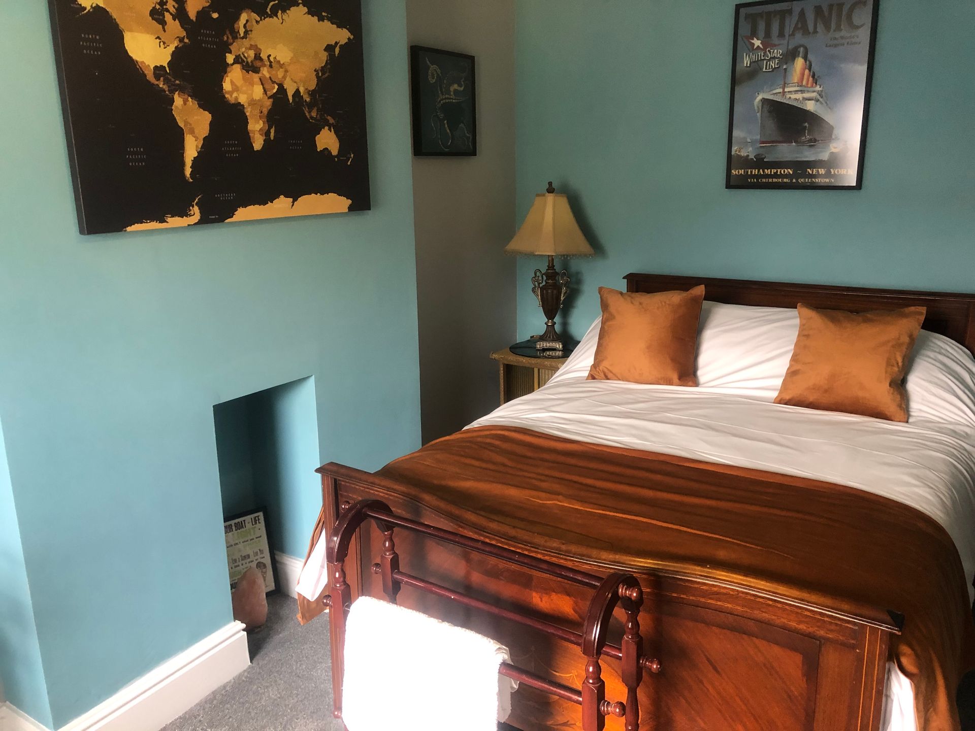 A bedroom with a bed and a titanic poster on the wall