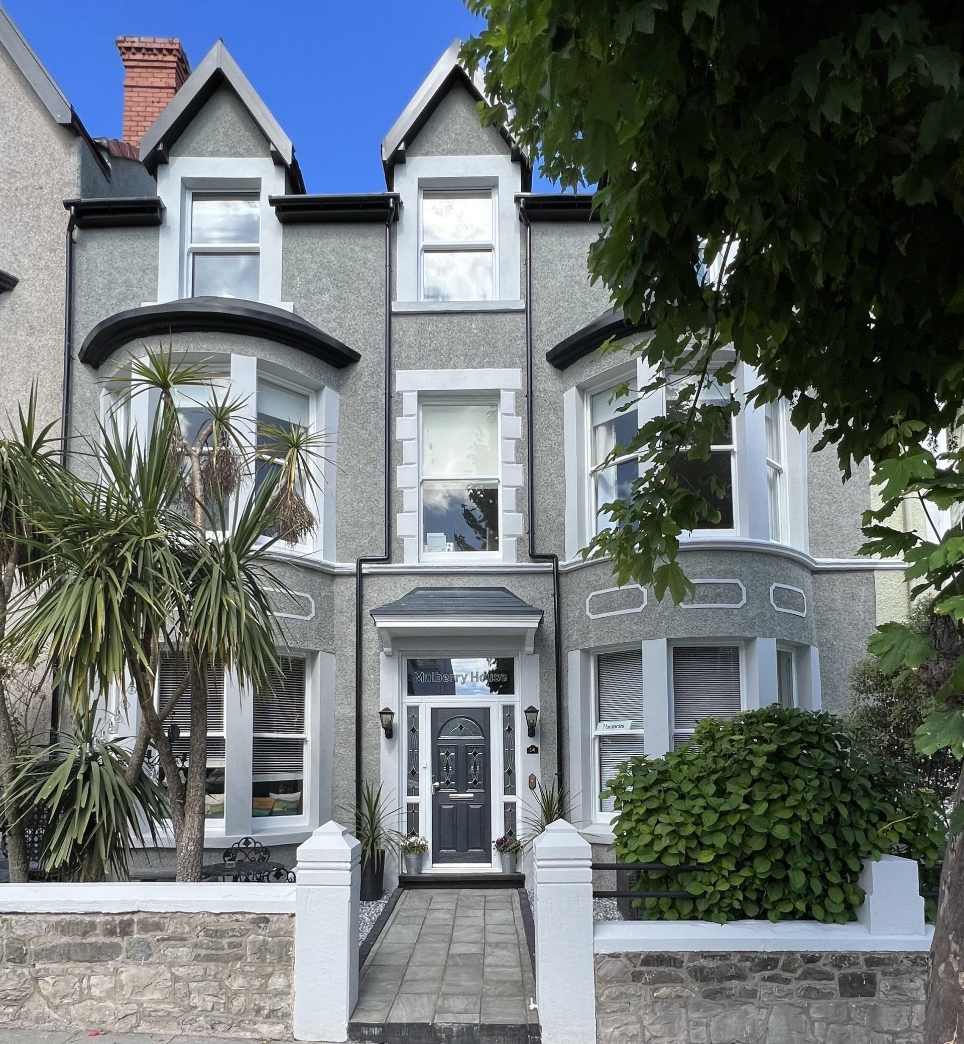 A large house with a blue sky in the background