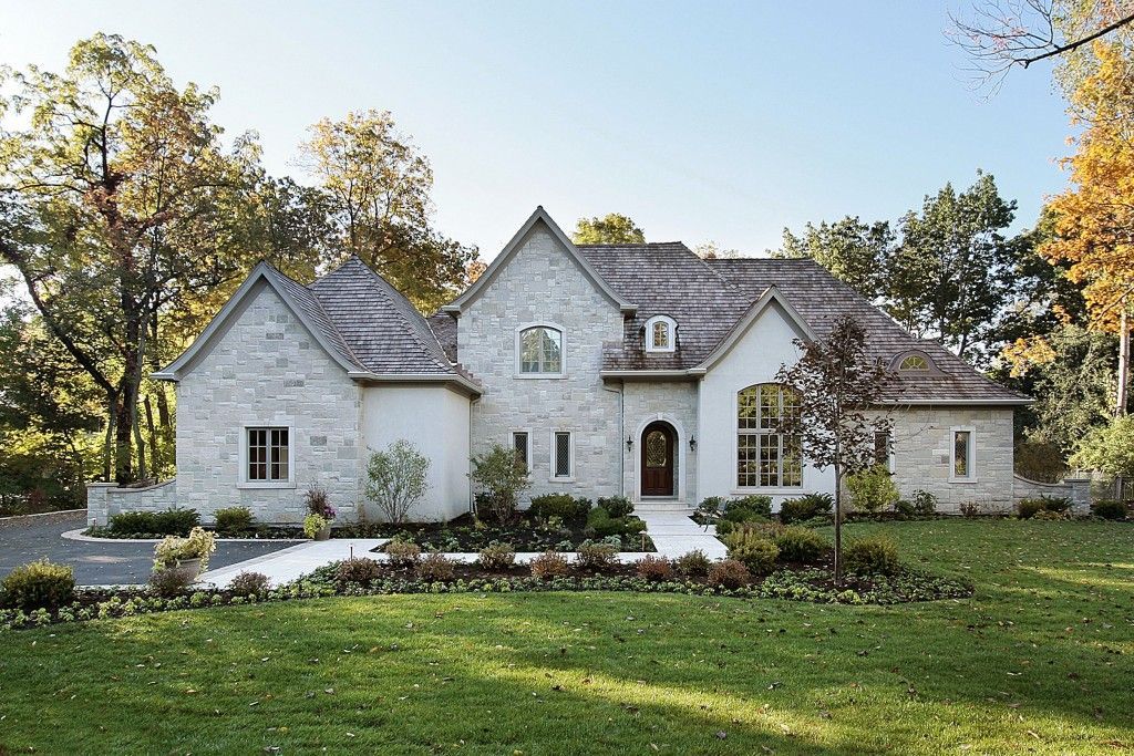 A large white house with a lush green lawn in front of it