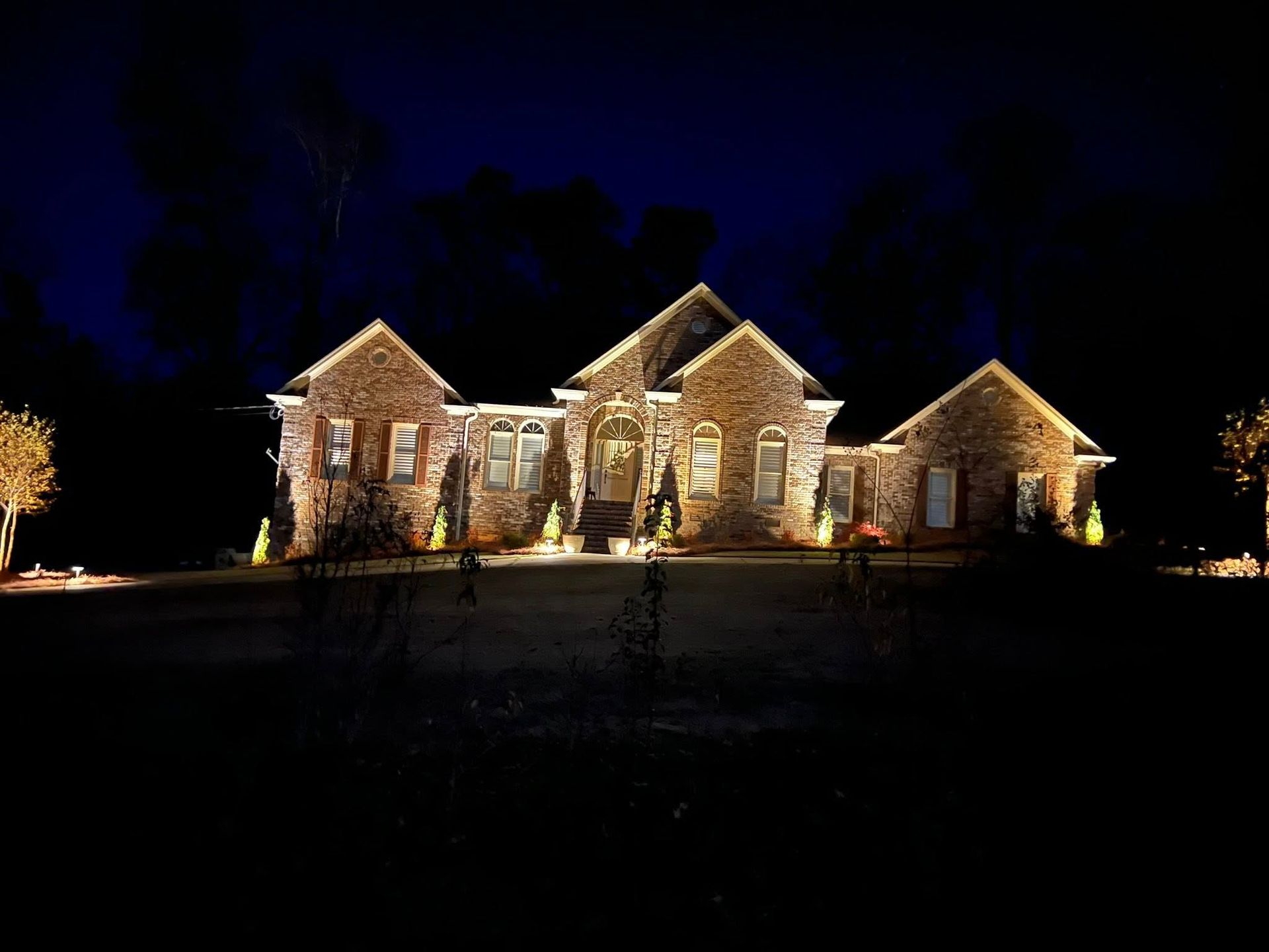 A large brick house is lit up at night.
