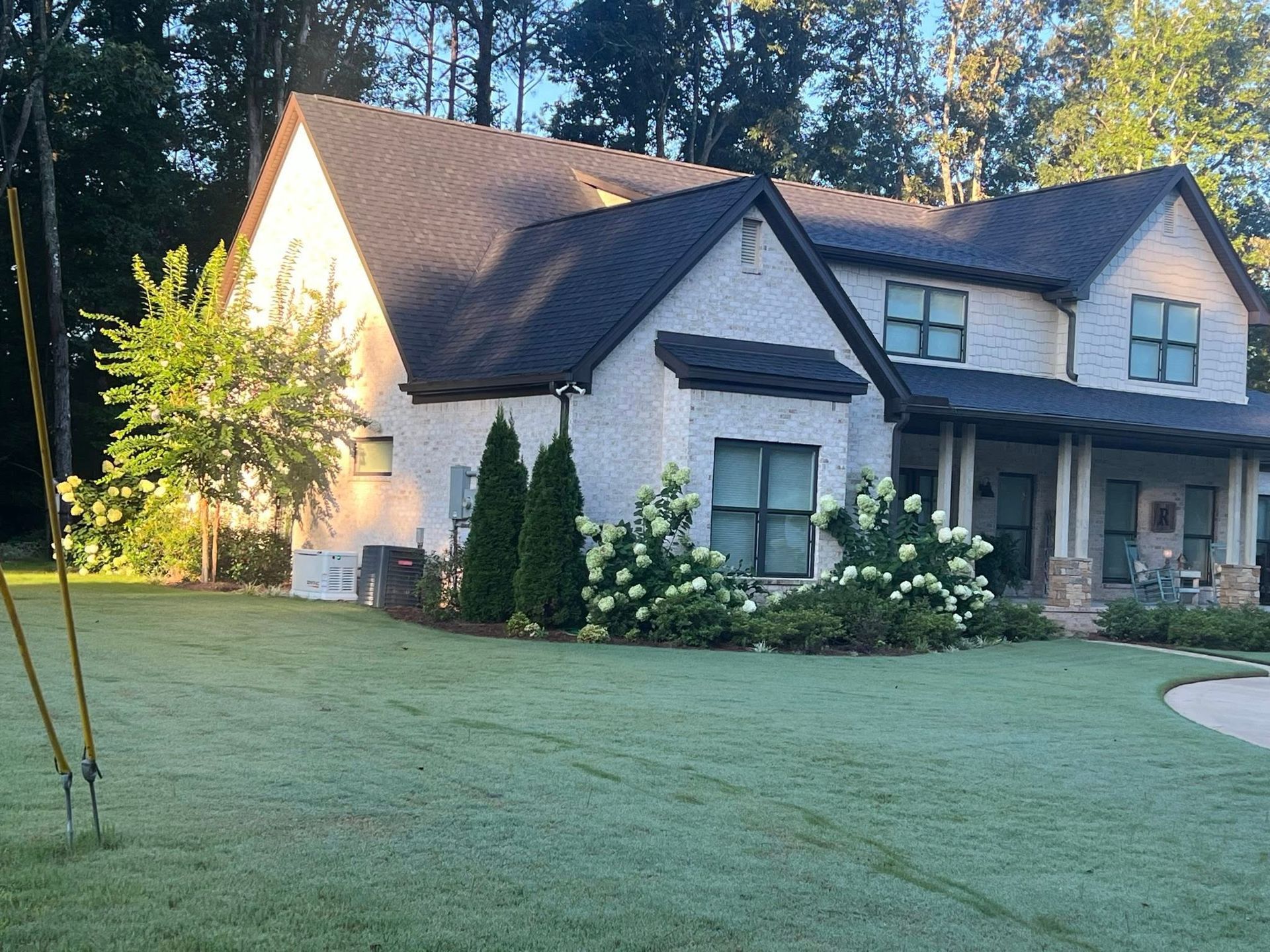 A large white house with a black roof and a porch
