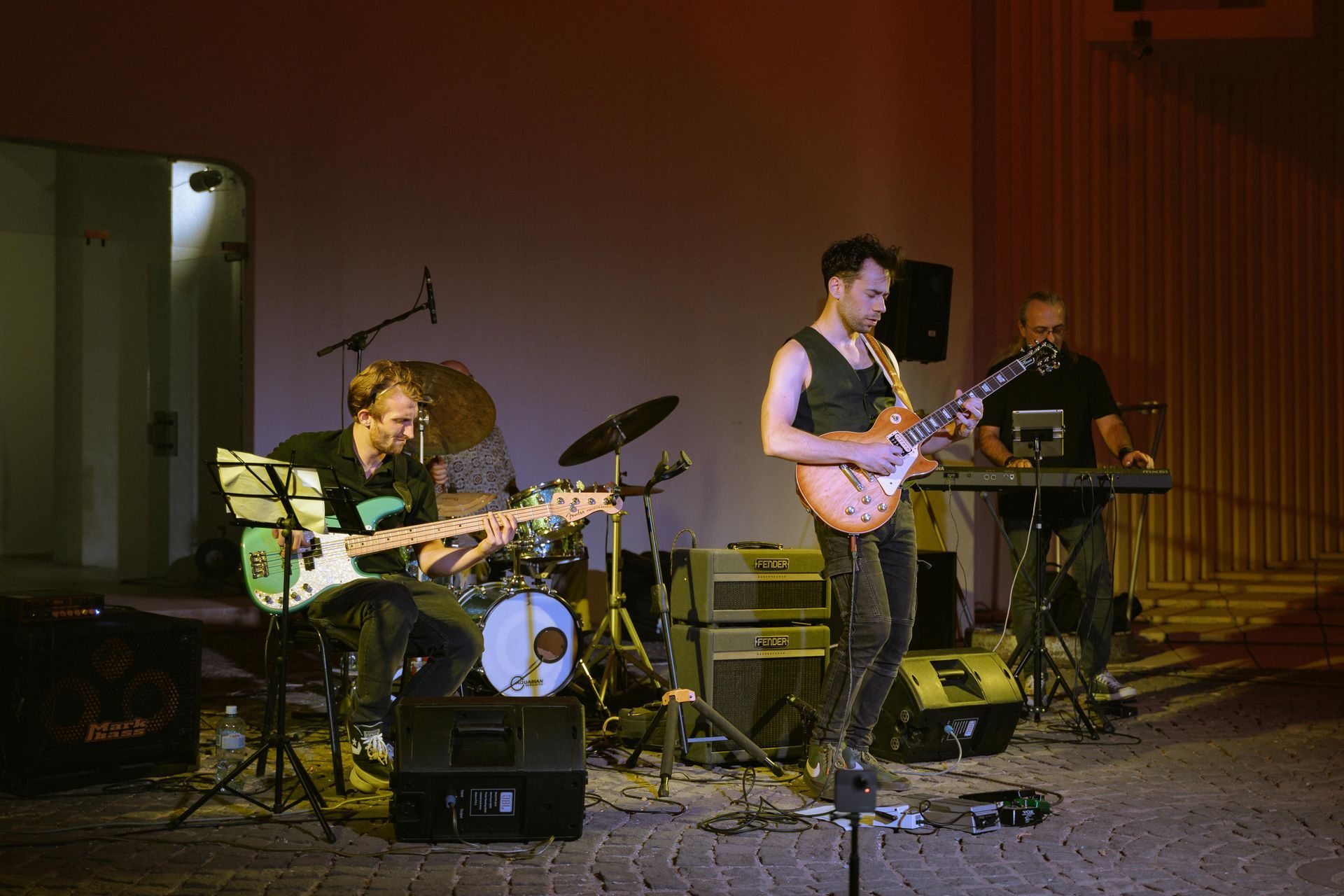 A man with tattoos on his arms is singing into a microphone