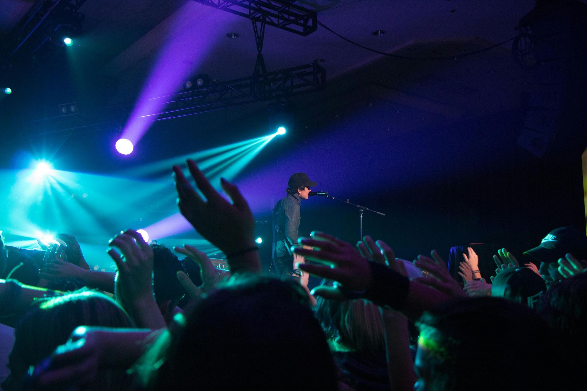 A man with tattoos on his arms is singing into a microphone