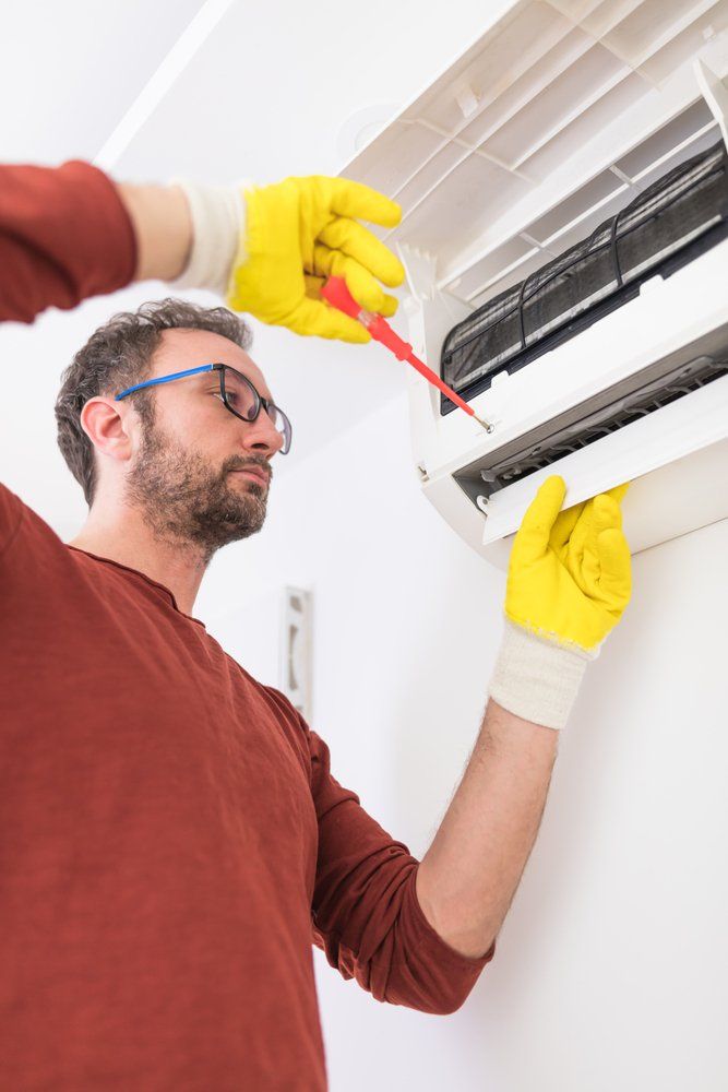 Man Servicing Air Conditioner — Air Conditioning Services in Wollongong, NSW