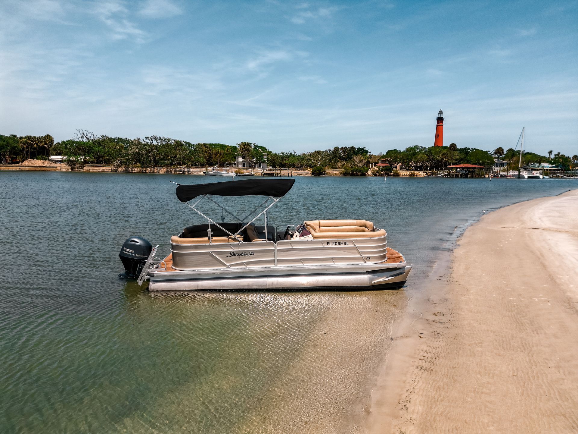 boat on beach with lighthouse