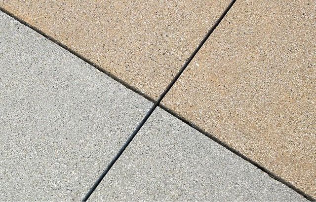 A close up of three different colored tiles on a sidewalk