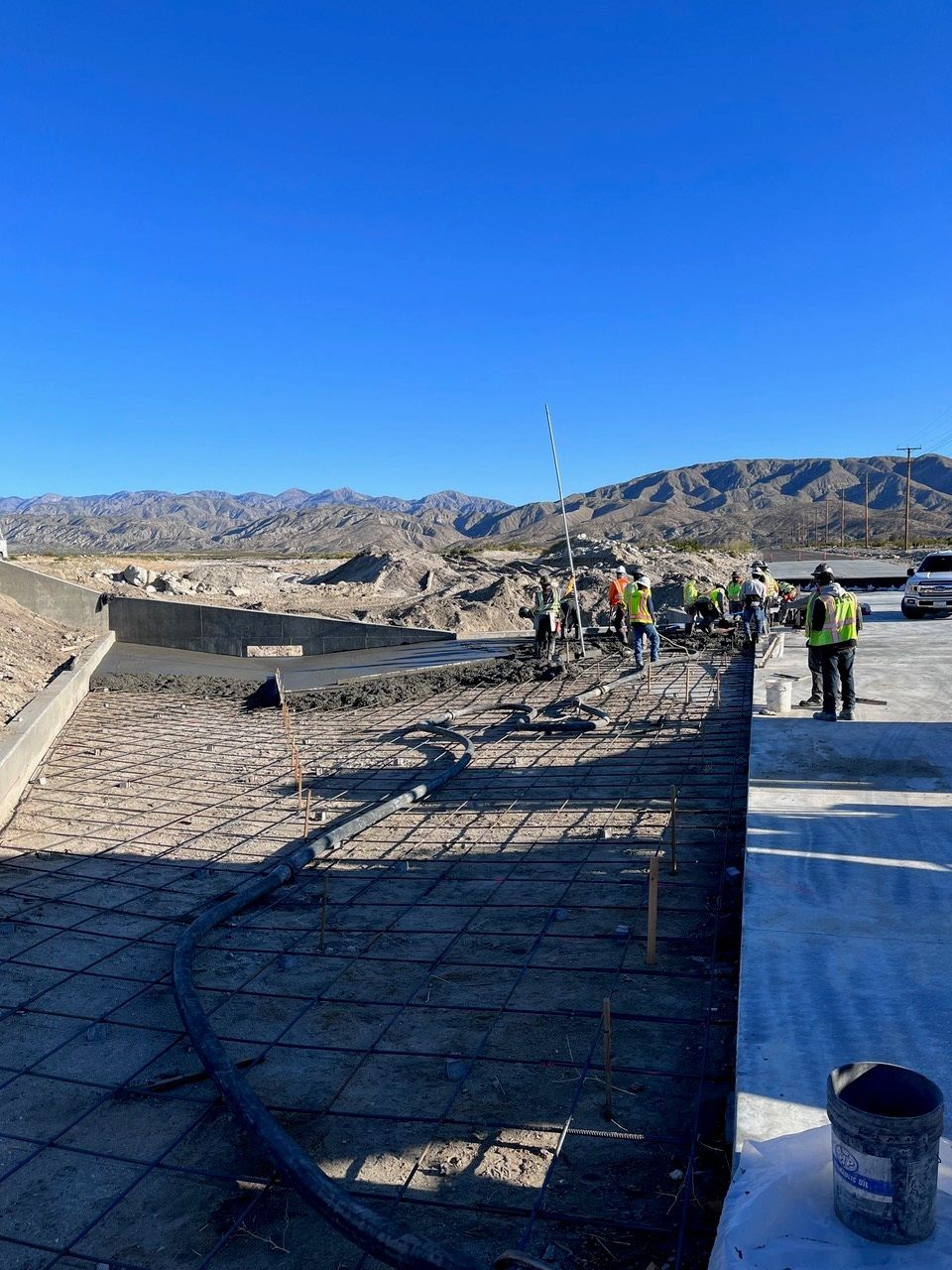 A group of construction workers are working on a concrete surface.