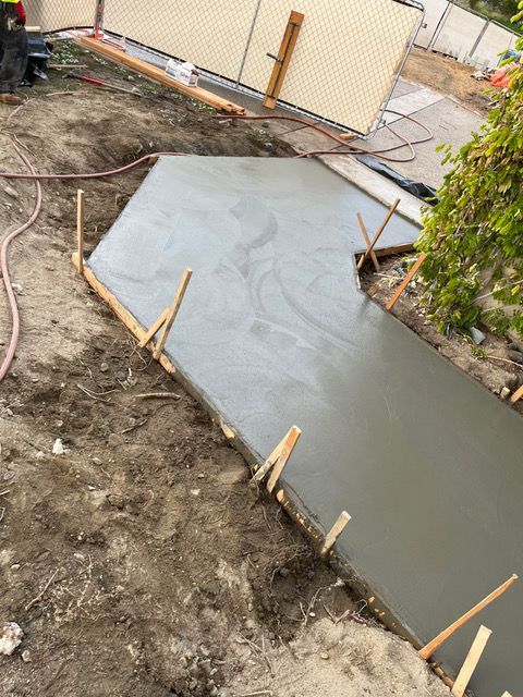 A concrete walkway is being built in the dirt.