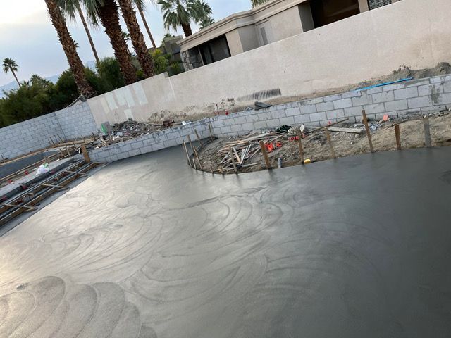 A swimming pool is being built in the backyard of a house.