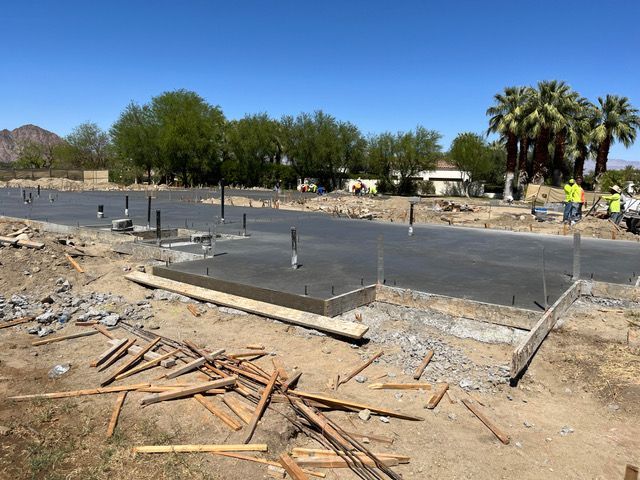 A group of construction workers are working on a concrete foundation.