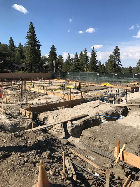 A construction site with a blue sky and trees in the background