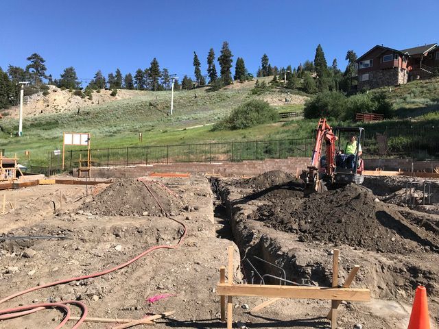 A construction site with a house in the background