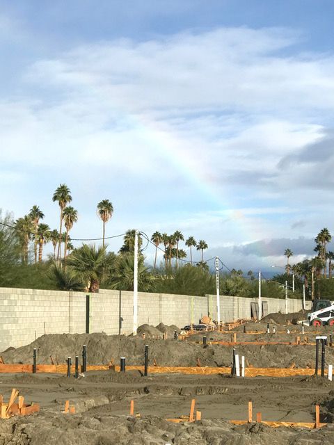 A construction site with a rainbow in the sky