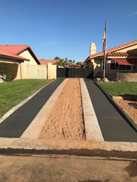 A concrete driveway is being built in front of a house.