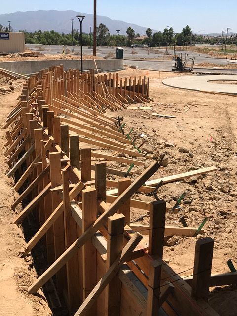A wooden fence is being built in the dirt