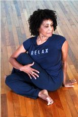 A woman is sitting on the floor wearing a relax shirt.
