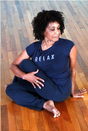 A woman is sitting on the floor wearing a relax shirt.