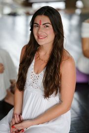 A woman is sitting on the floor wearing a relax shirt.