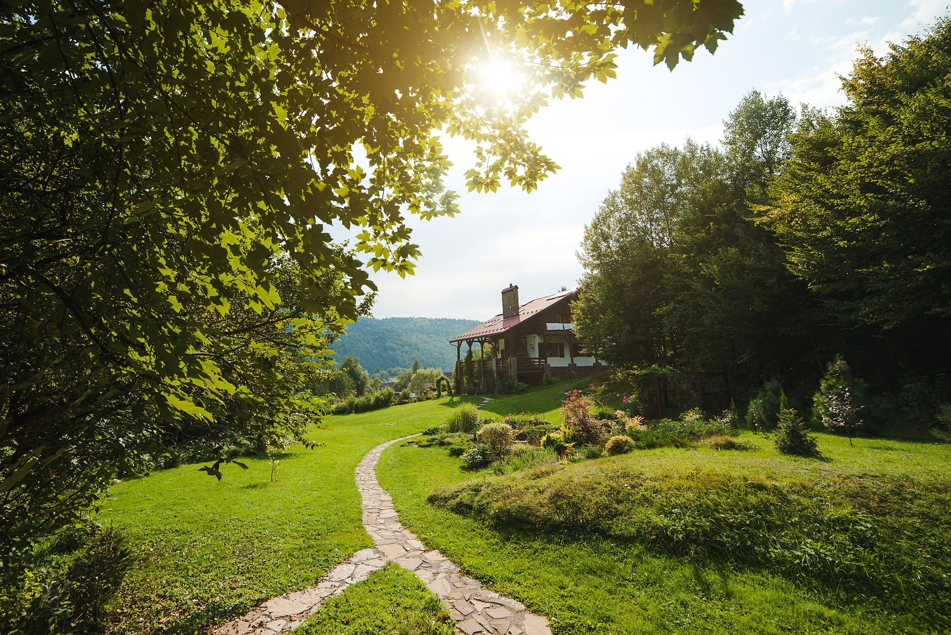 Suburban houses with light blue siding and dark roofs under a sunset.