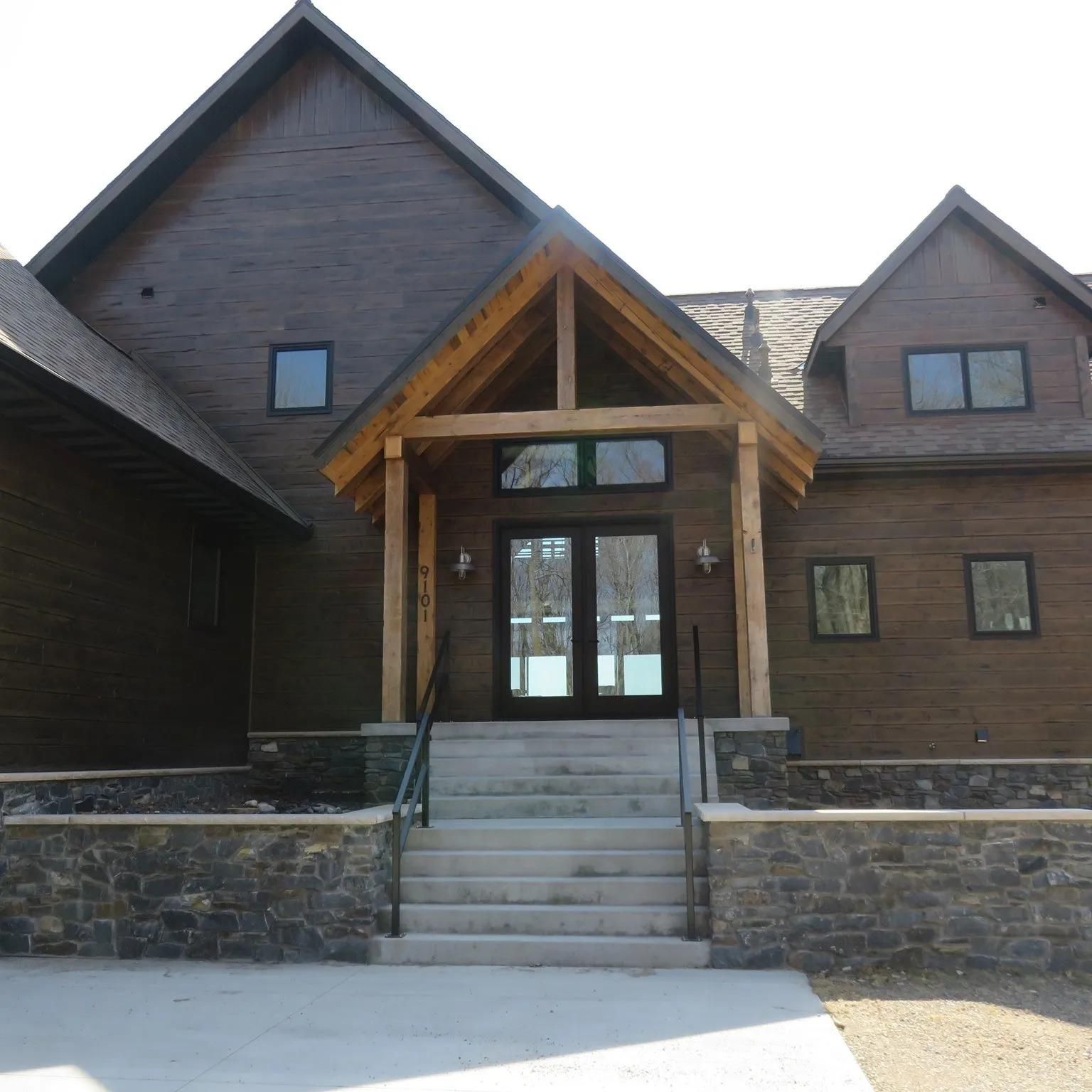 A Large Brown House With Stairs Leading Up To The Front Door | Park Falls, WI | Park Falls Building