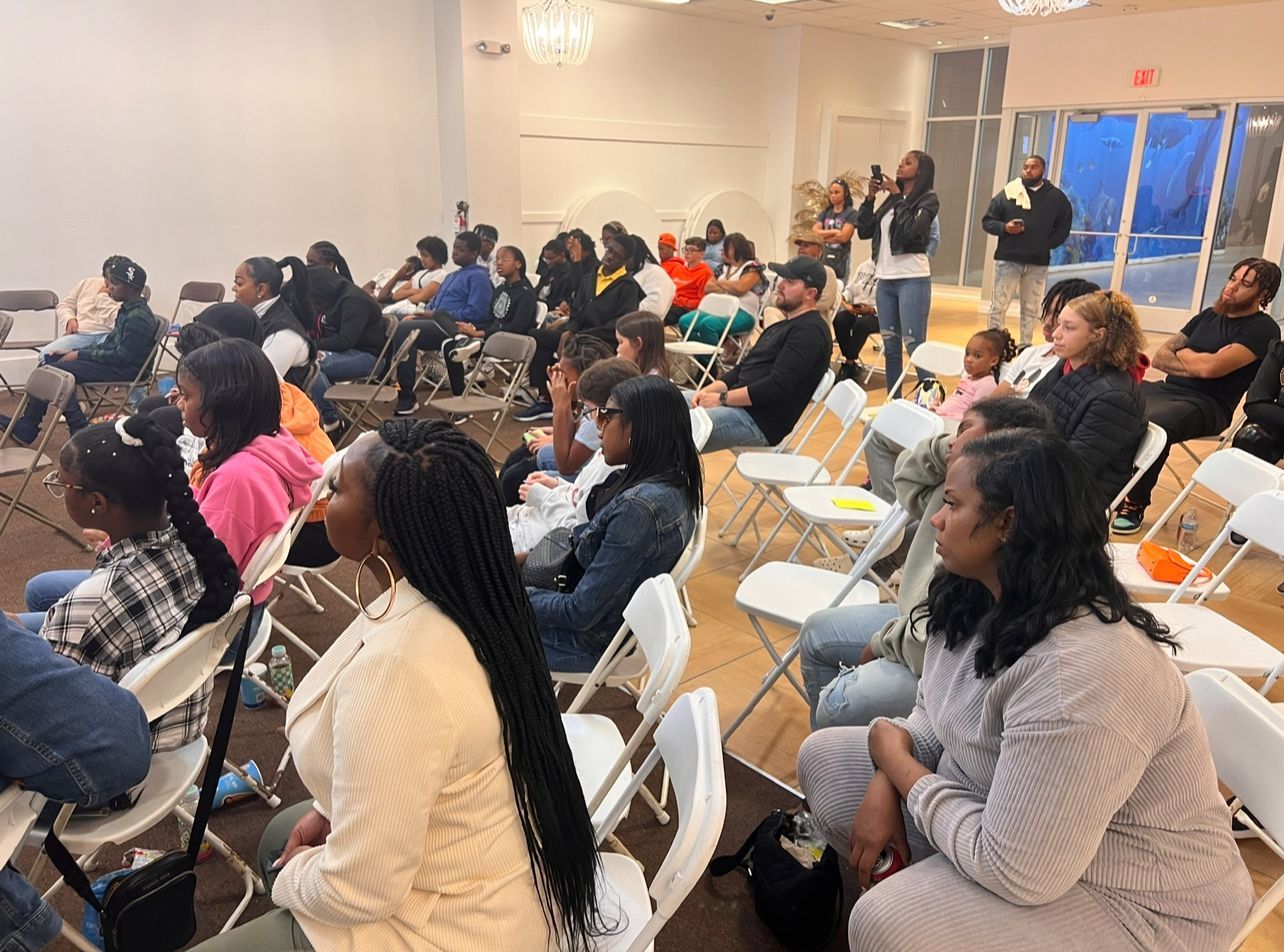 A group of people are sitting in folding chairs in a room.