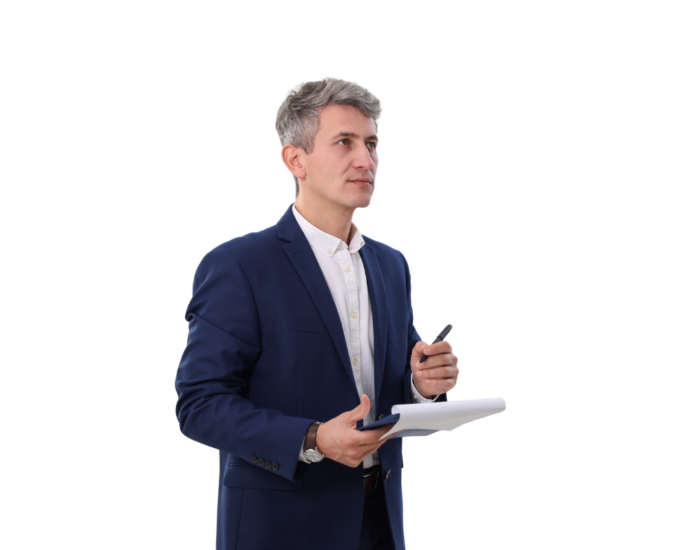 Man in blue suit, holding notepad and pen, looking to the side.