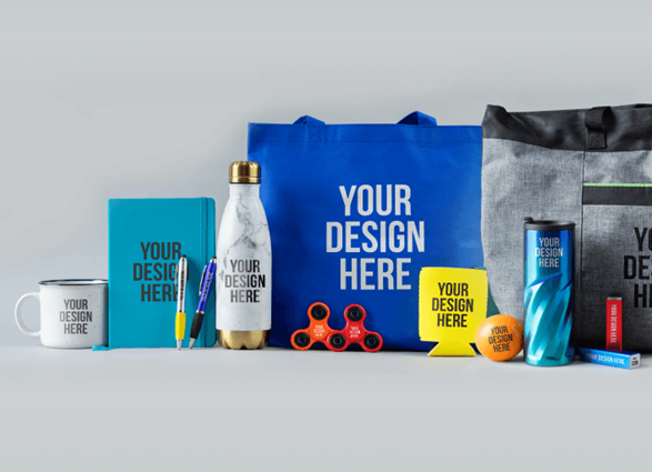 Promotional products laid out; a mug, water bottle, tote bag, notebook, pens, fidget spinners, and other branded items.