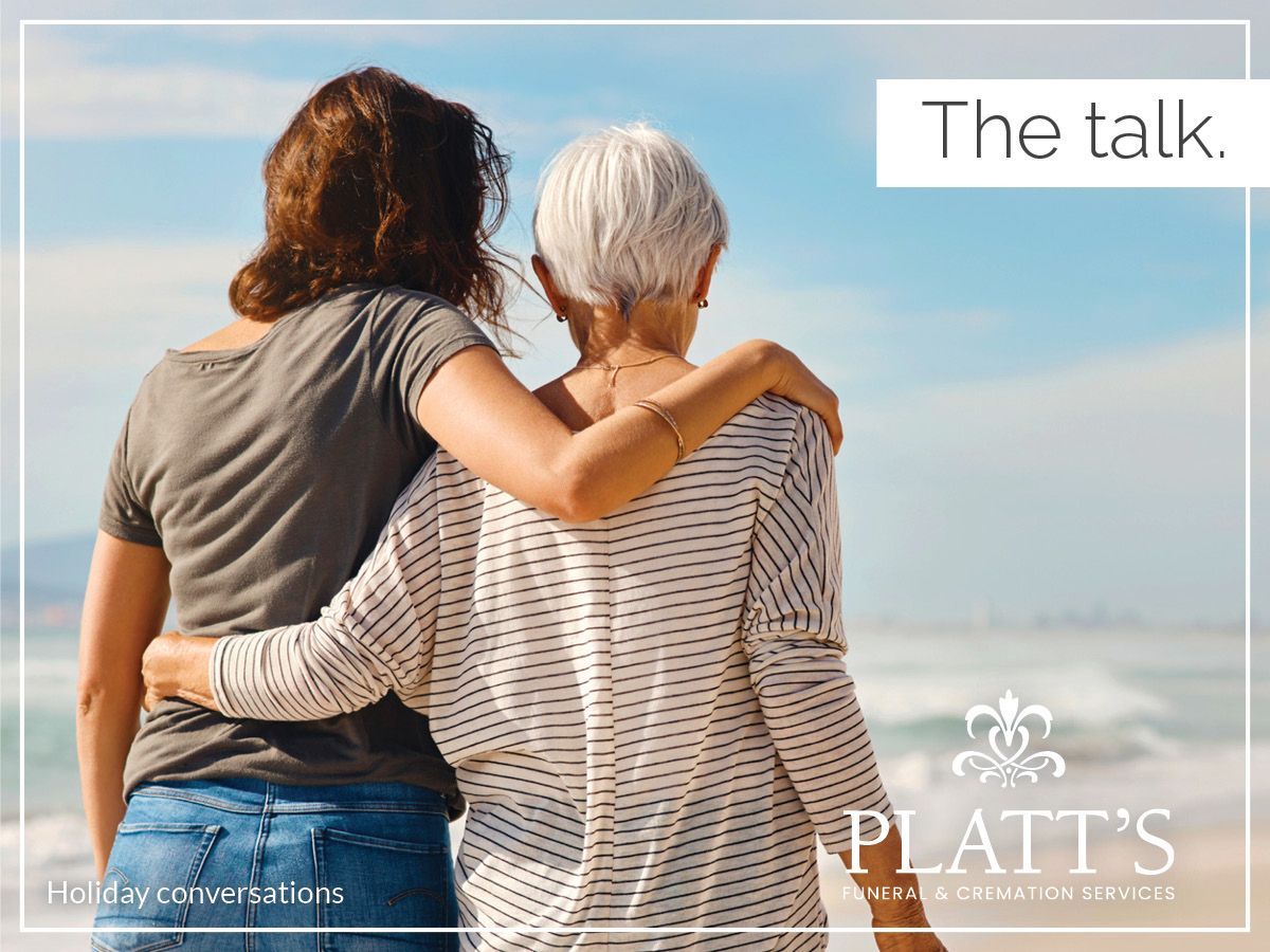 Mother and daughter on beach with arms around each other;