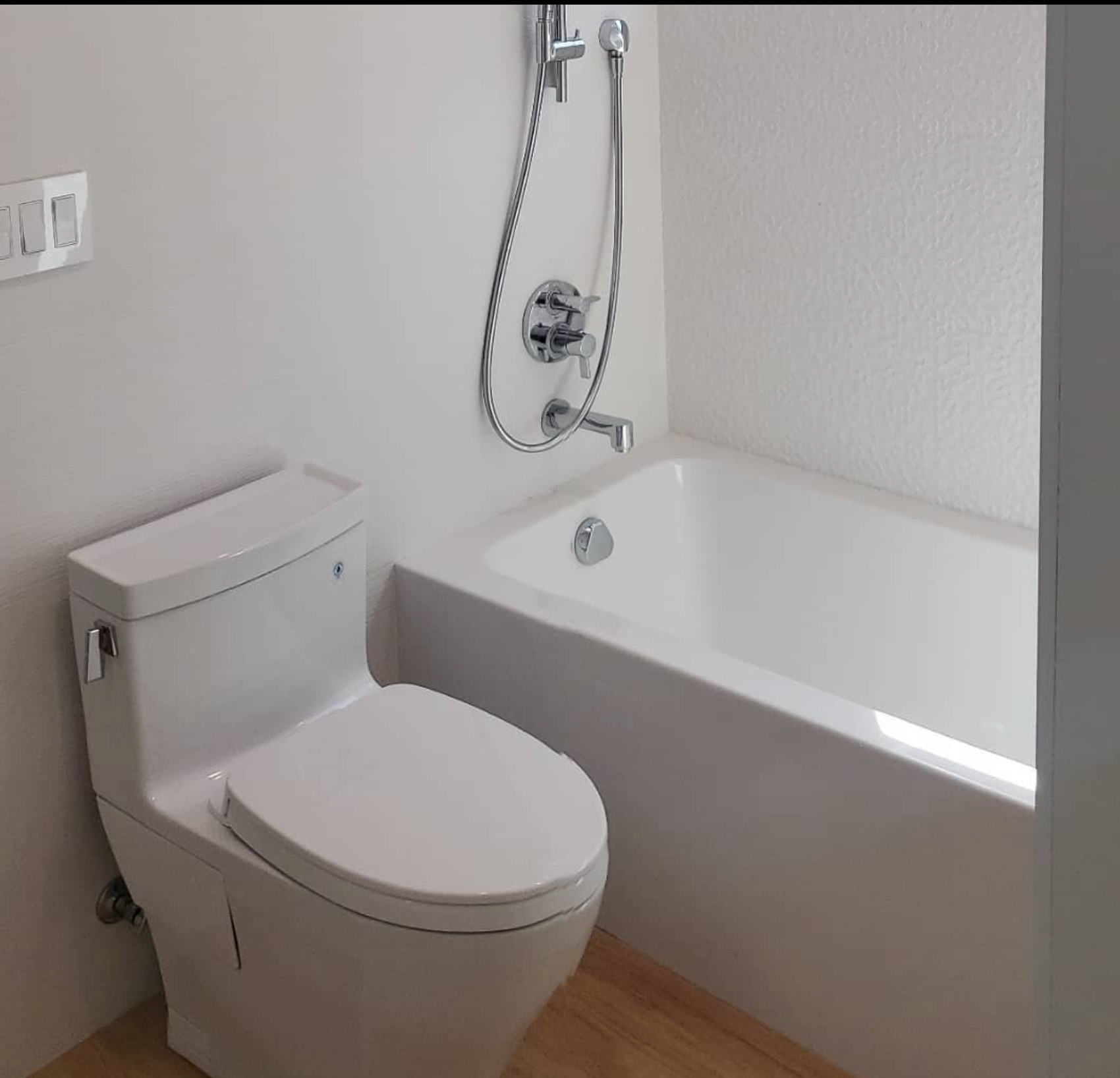 A bathroom with a toilet a bathtub and a shower
