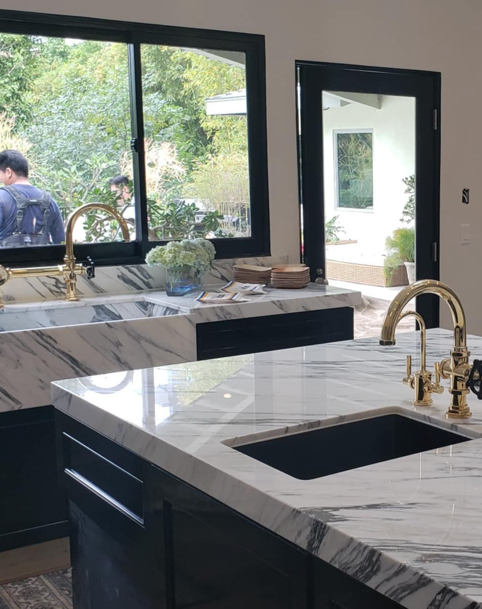 A kitchen with marble counter tops and a sink