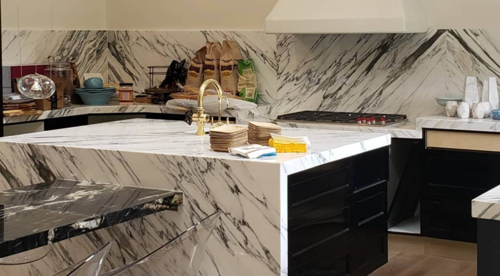 A kitchen with marble counter tops and black cabinets