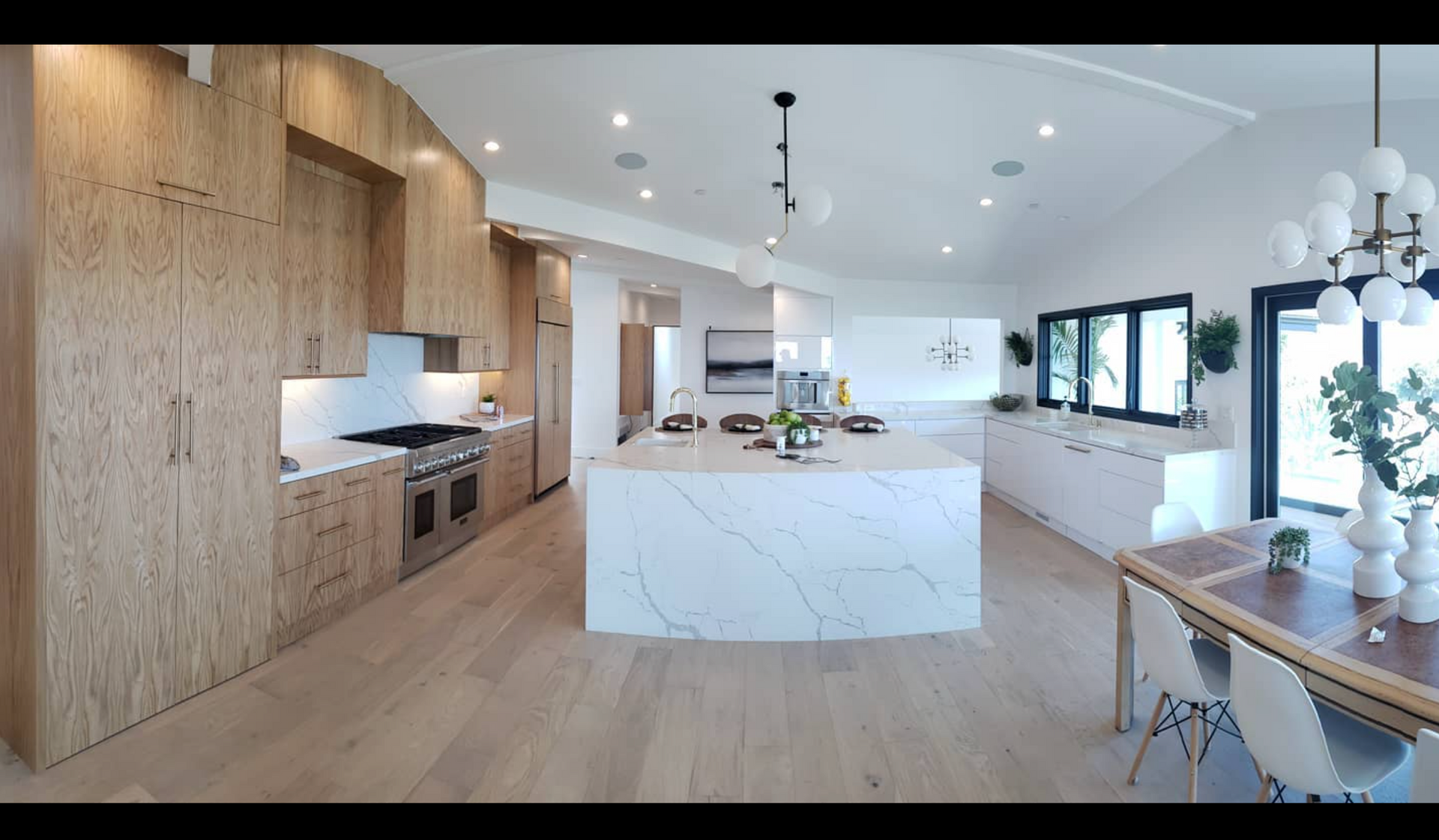 A kitchen with wooden cabinets and a large island in the middle.