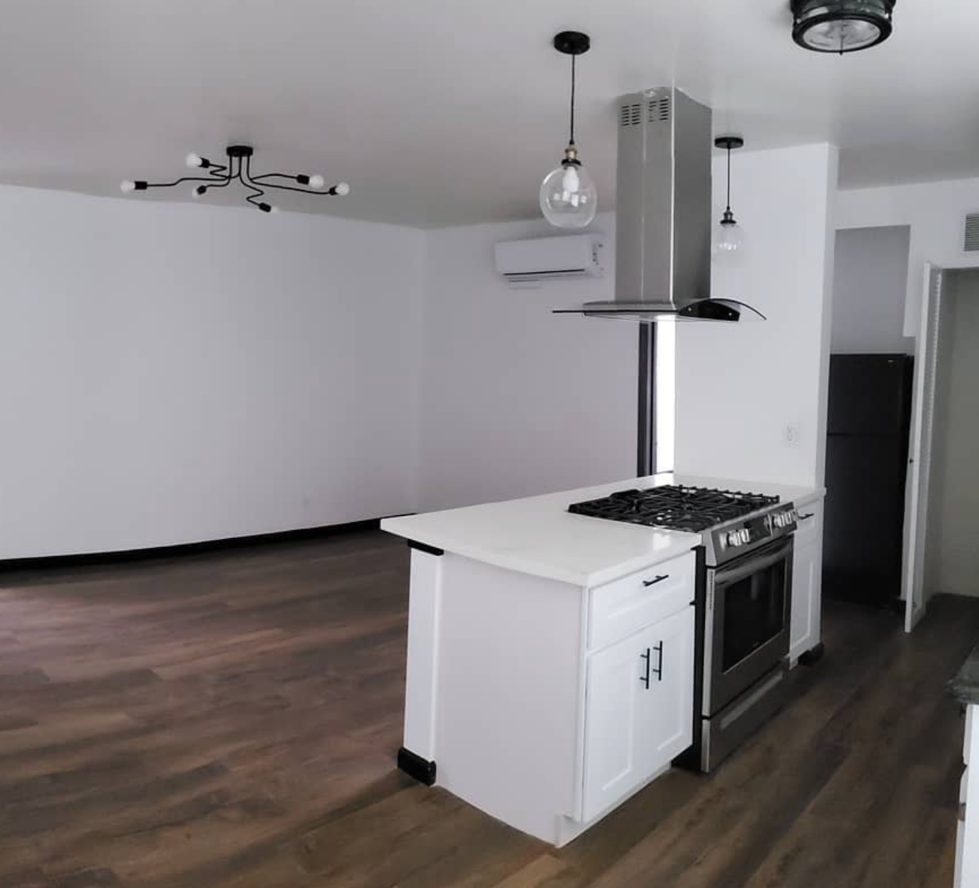 An empty kitchen with a stove and a refrigerator