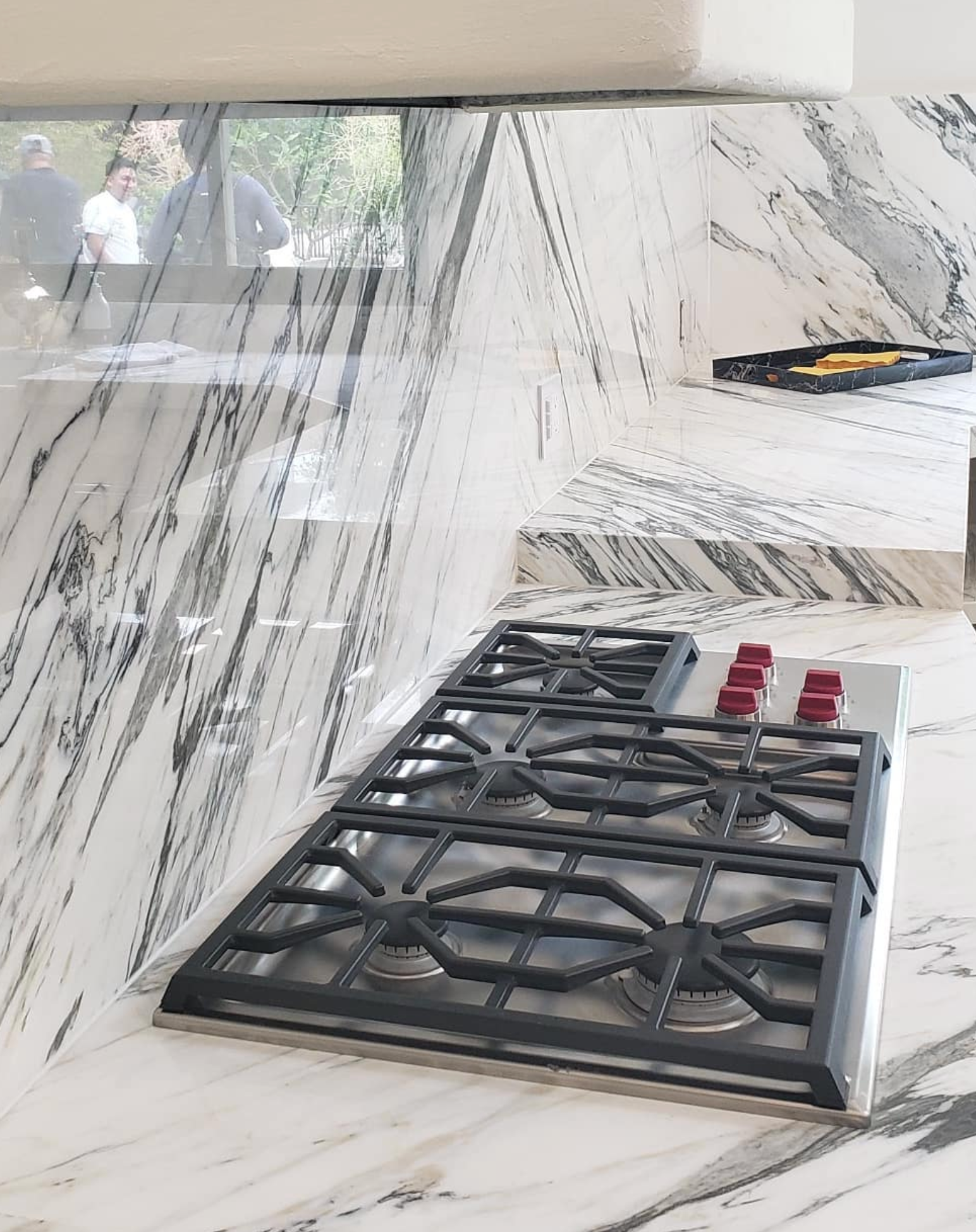 A stove top oven is sitting on top of a marble counter top in a kitchen.