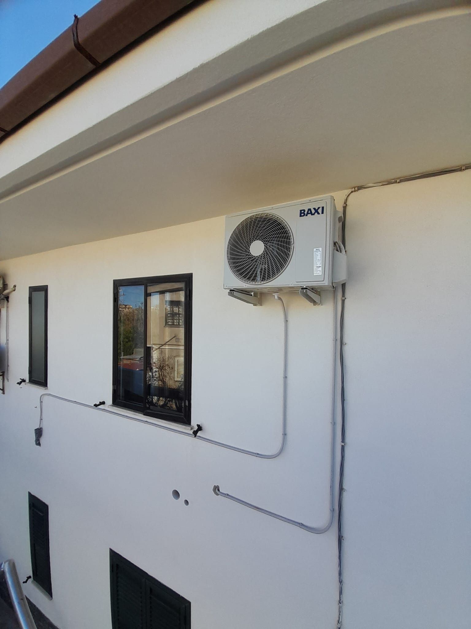 Un edificio bianco con un ventilatore su un lato