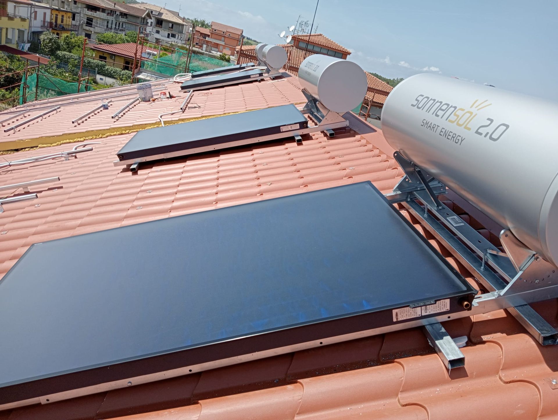 Una fila di pannelli solari è posizionata sopra un tetto di tegole.