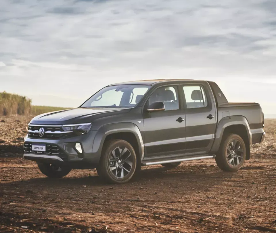 A volkswagen amarok is parked in a dirt field.