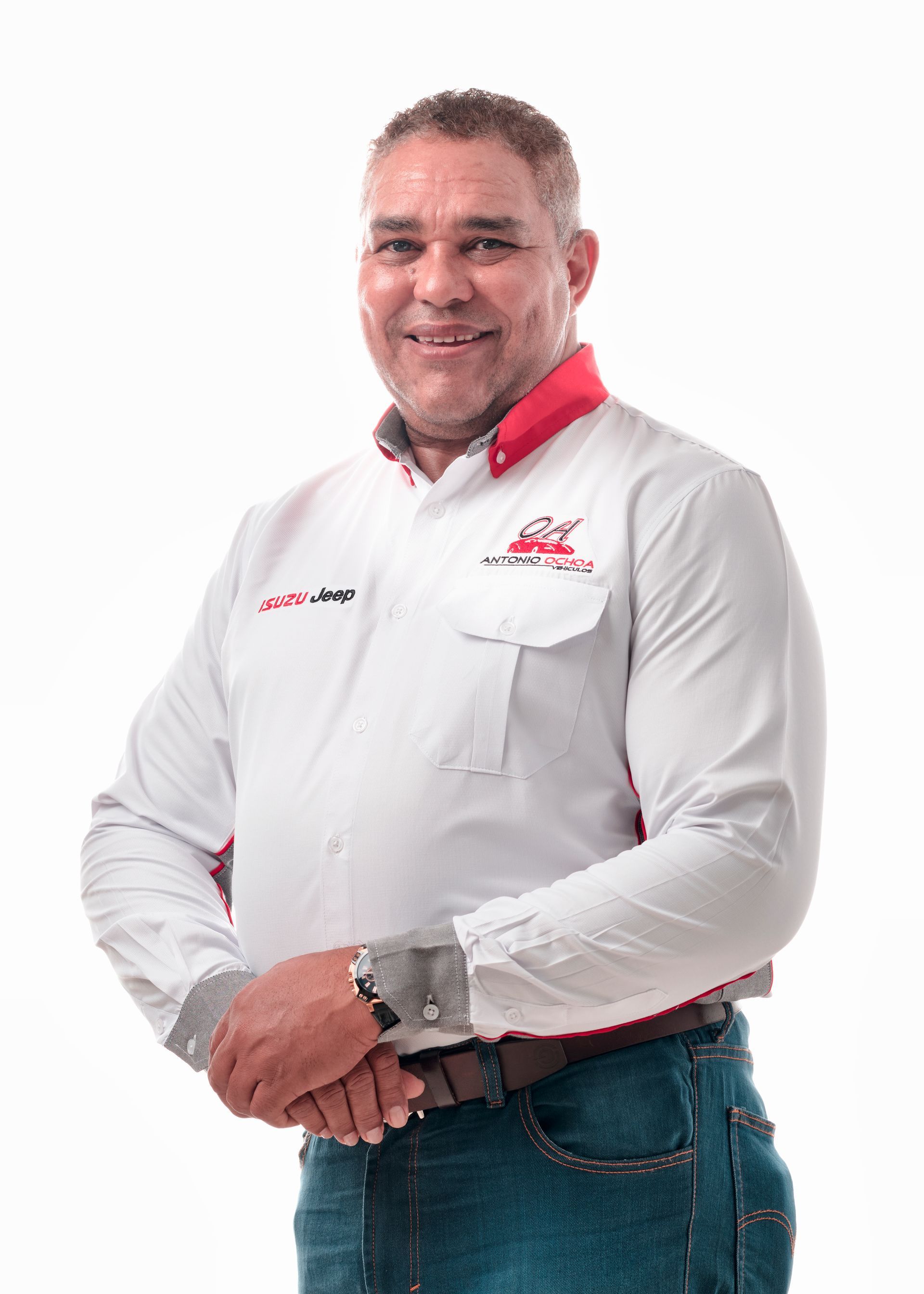 A man in a white shirt and blue jeans is standing in front of a white background.