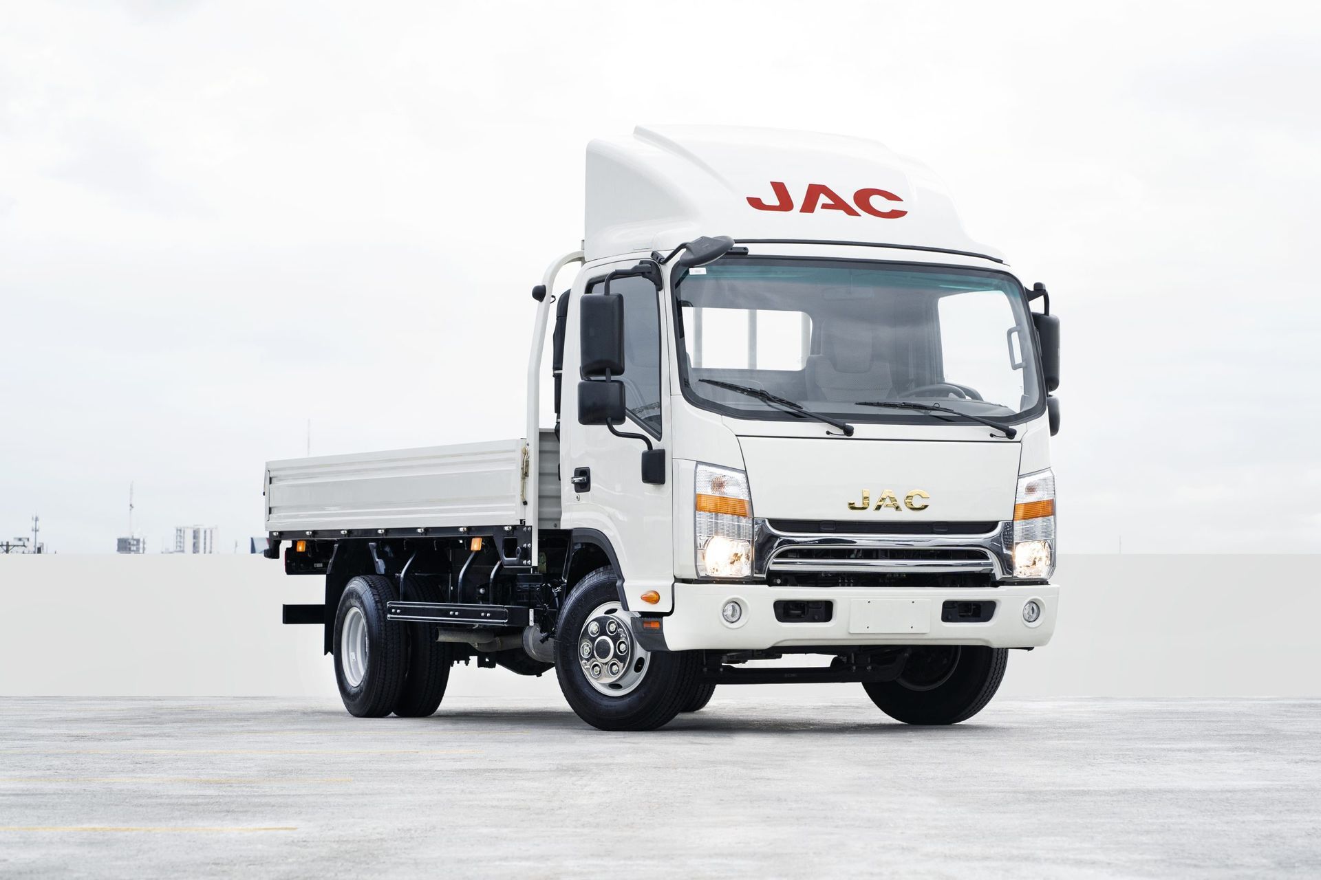 A white jac truck is parked on the side of the road.