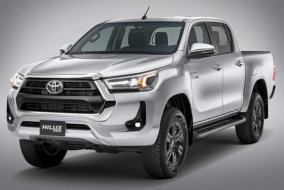 A silver toyota hilux pickup truck is parked on a gray background.