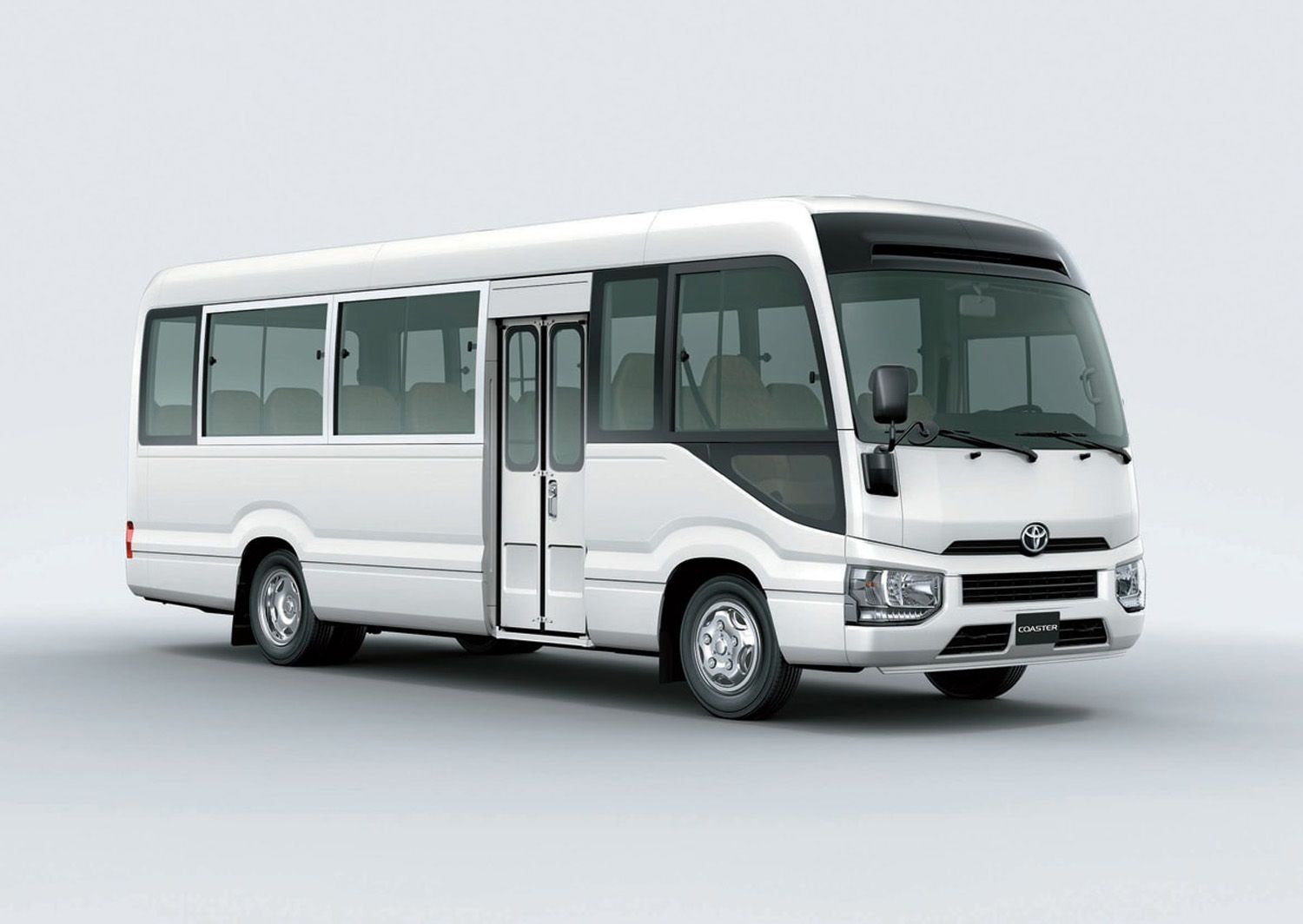 A white bus is parked on a white surface.