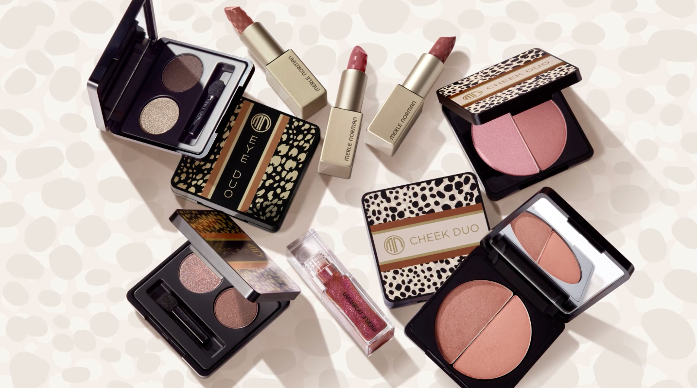 Makeup products including eyeshadow palettes, lipsticks, and blush with animal print and gold accents.