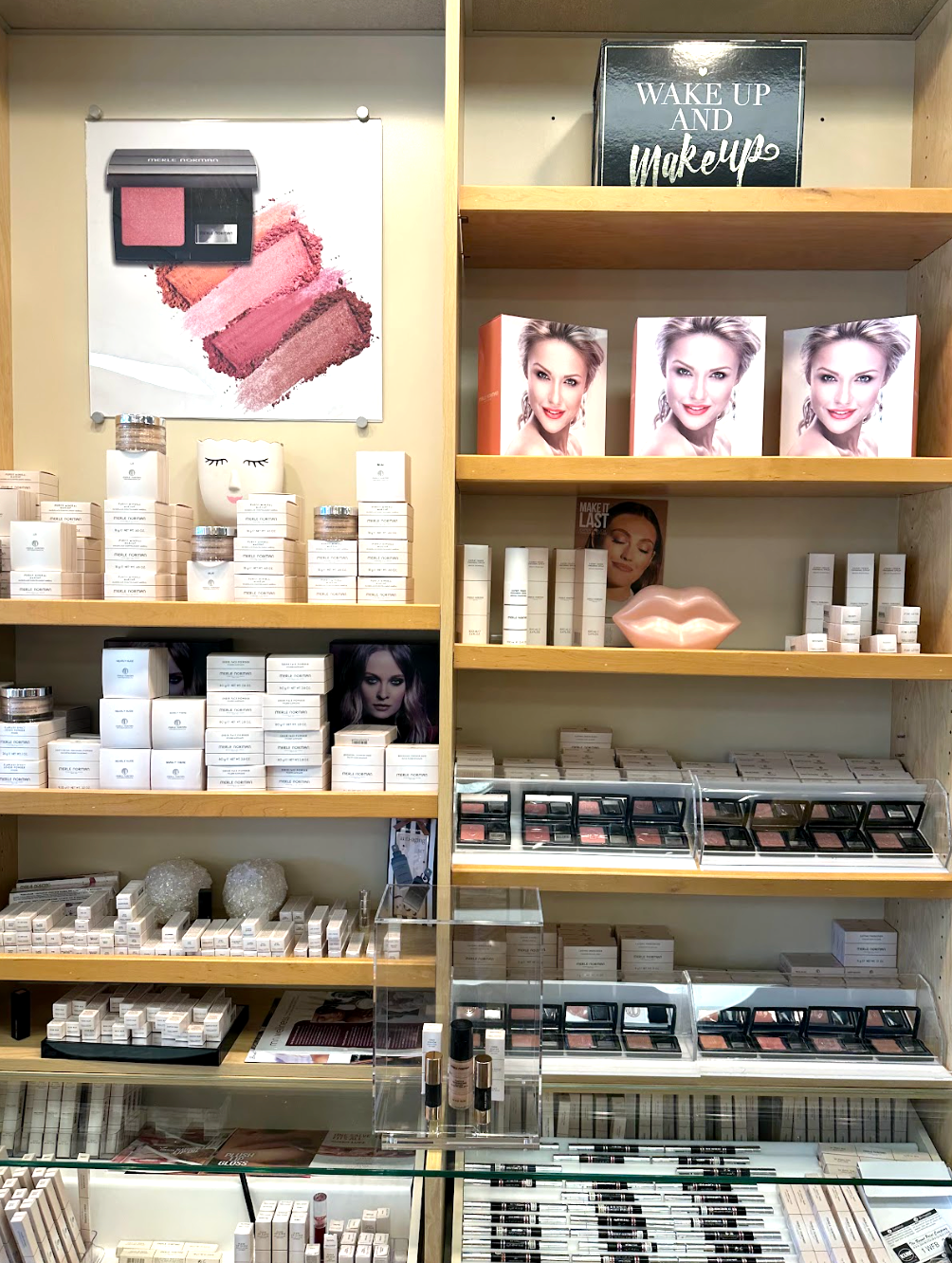 Shelves stocked with skincare and makeup products in a store. Displays and posters feature cosmetics.