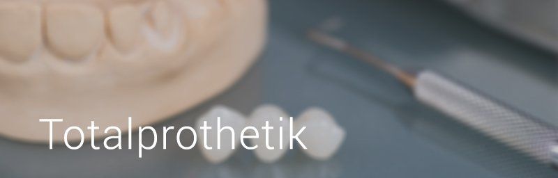Zahnärztliche Instrumente und Zähne in einer Laborumgebung, mit dem Wort „Totalprothetik“ im Vordergrund.