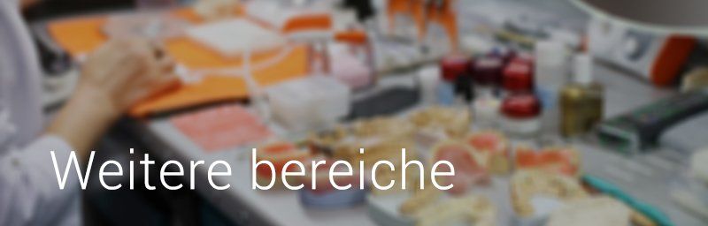 Ein Arbeitsplatz mit verschiedenen Objekten. Darüber ist der weiße Text „Weitere Bereiche“ eingeblendet.