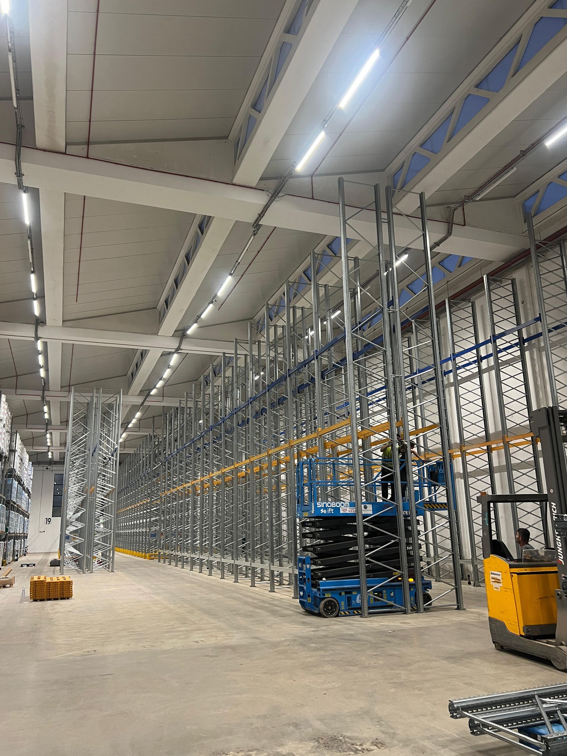 Un grande magazzino con molti scaffali e un carrello elevatore.