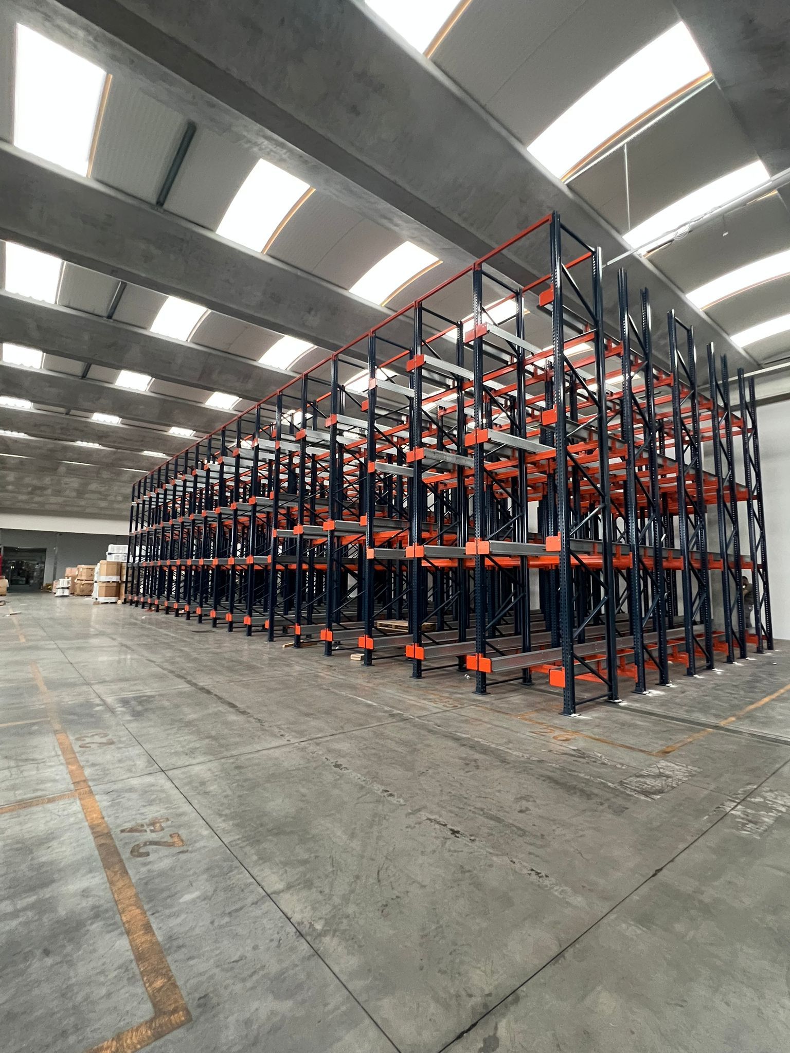 Un grande magazzino pieno di scaffali e pallet.