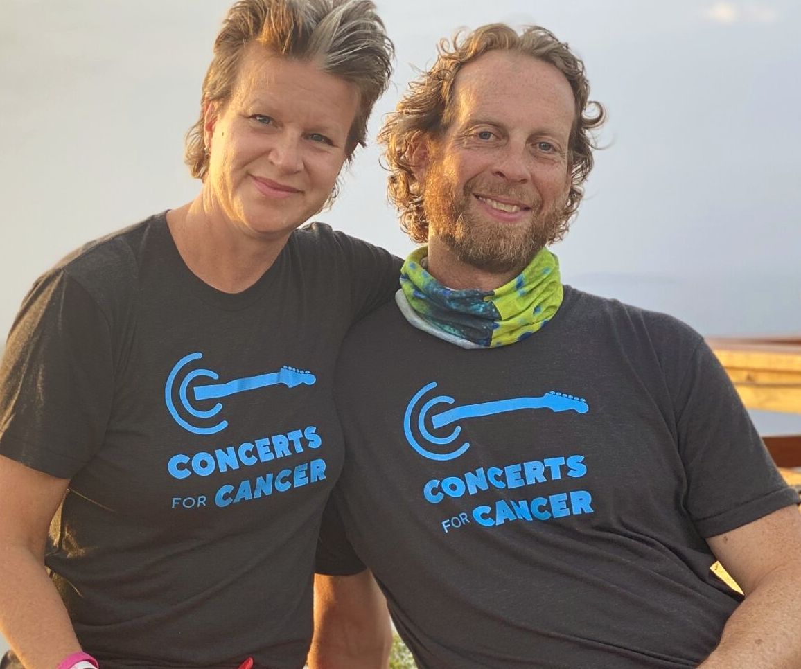 A man and a woman wearing concerts for cancer shirts